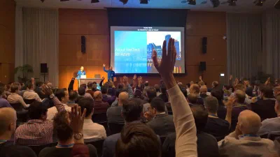 Chris presenting at Microsoft Ignite Tour in Amsterdam, with the audience raising their hands in response to a question