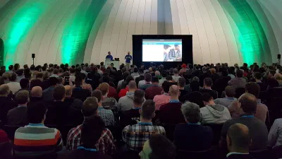 Chris presenting on stage to a packed room at a Microsoft Tech Summit event